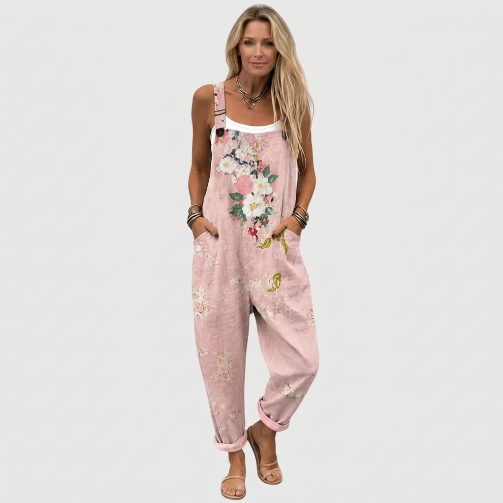 Full-length front view of a model wearing the loose, cuffed overalls with a white vest and flat sandals. 2