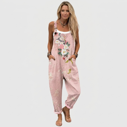 Full-length front view of a model wearing the loose, cuffed overalls with a white vest and flat sandals. 2