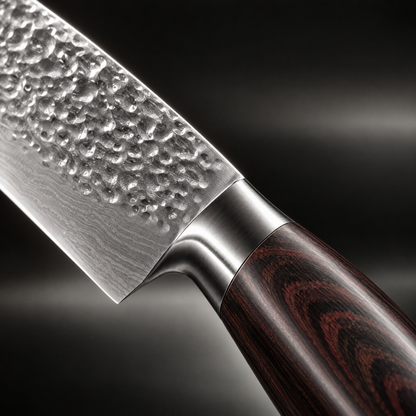 Close-up of the hammered blade, steel bolster and grain of the dark wooden handle 3