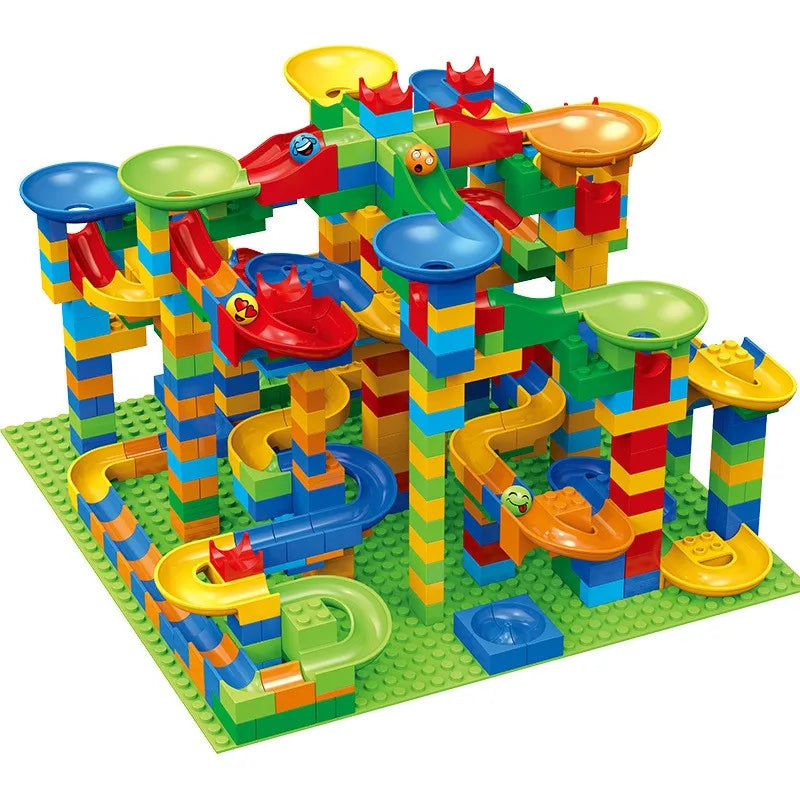 Large, tall marble run build in blue, green, yellow and red, with funnels, slides and smiley-faced balls on a green baseplate. 2