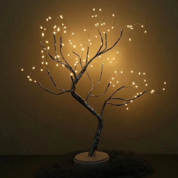 Bare, wide-spreading branches of the lit tree lamp, glowing against a dark wall on a fluffy rug 4