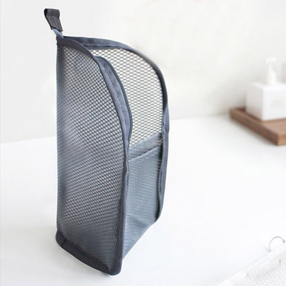 Side view of a grey mesh pouch standing upright on a white surface, showing the curved shape, top loop and front pocket. 7