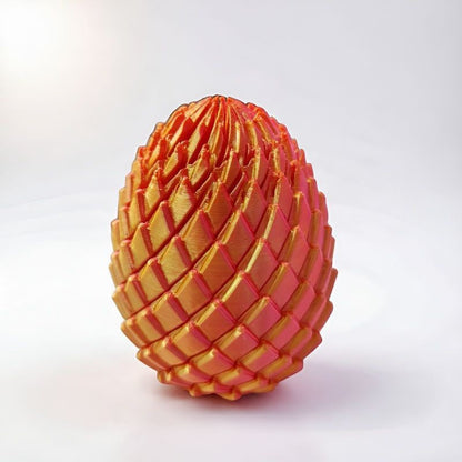Closed egg covered in overlapping scales in an orange and golden finish, standing on a white surface. 9