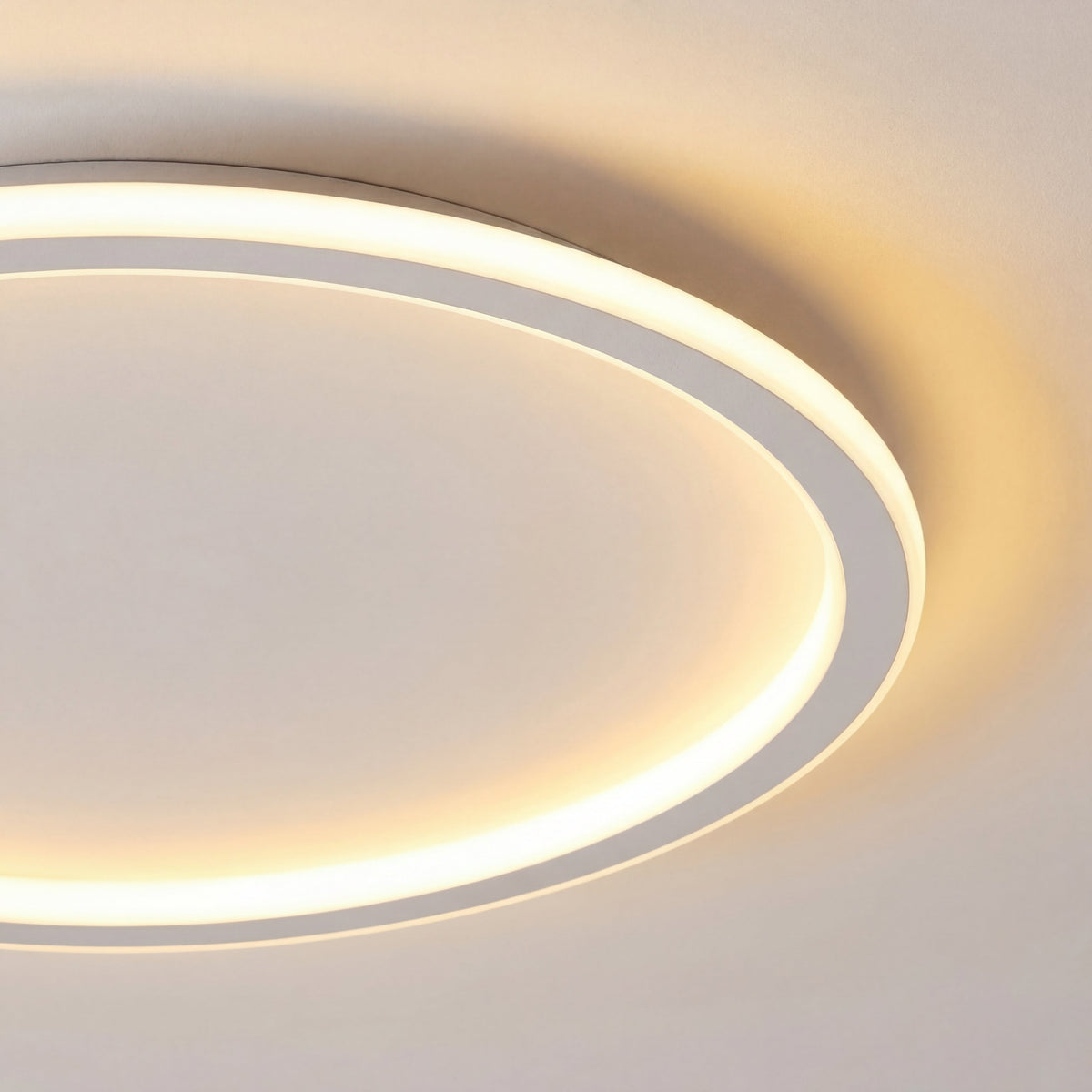 Close-up of the light's white ring edge and softly glowing inner band, showing the thin profile and warm glow on the ceiling. 2