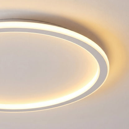 Close-up of the light's white ring edge and softly glowing inner band, showing the thin profile and warm glow on the ceiling. 2