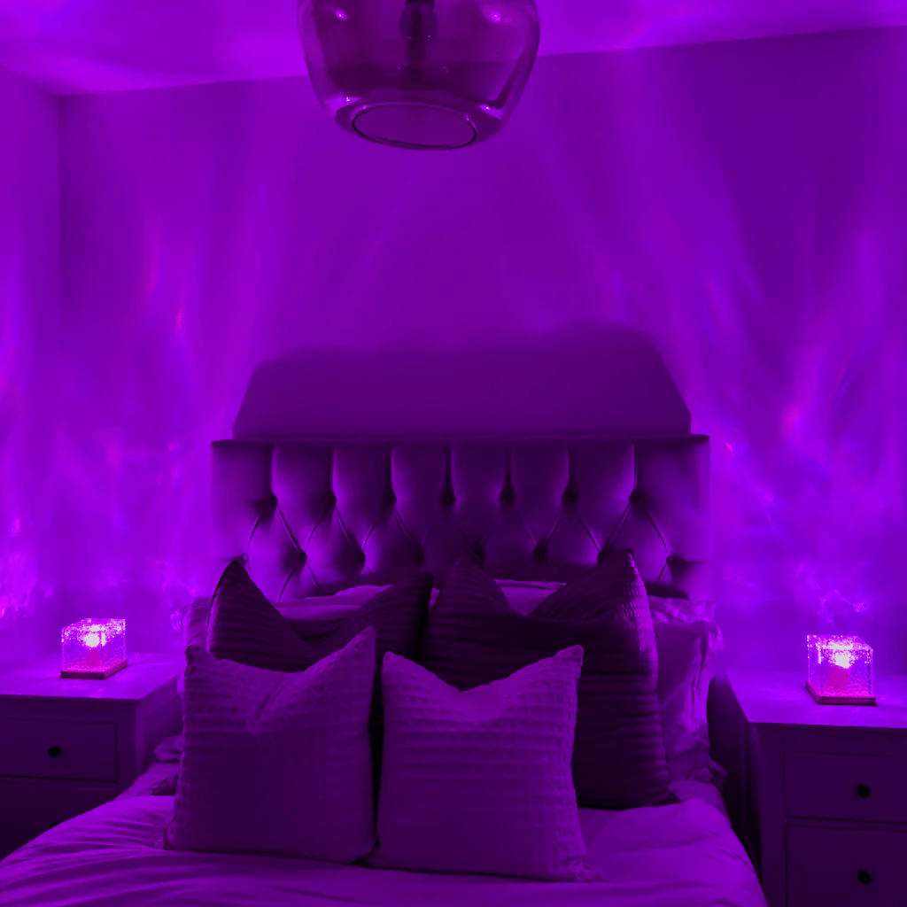 The same bedroom bathed in purple light, with two cube lamps on the bedside tables projecting soft waves up the walls. 3