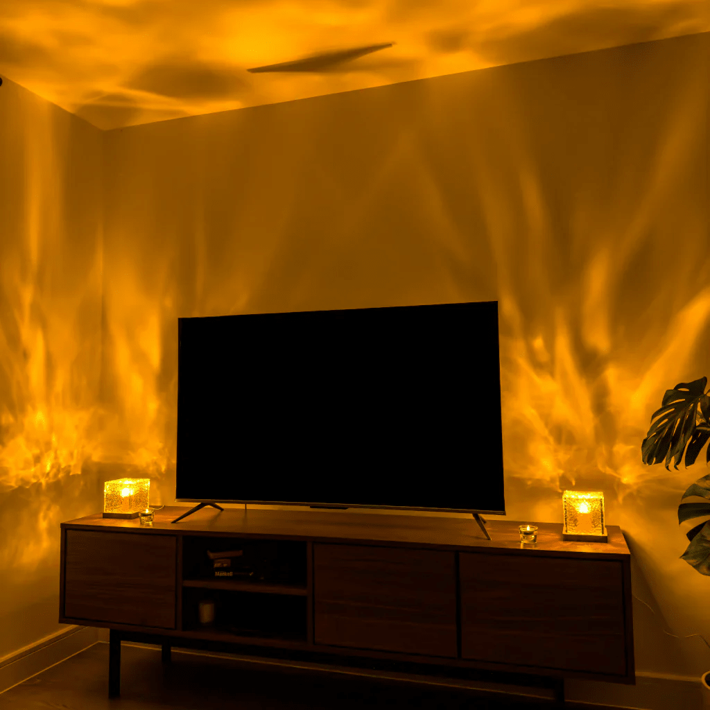 Two glowing cube lamps on a wooden TV unit throw golden flowing light patterns over the walls and ceiling of a living room. 4