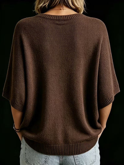 Back view of the brown batwing knit top worn with light denim jeans, showing ribbed round neckline, cuffs and hem. 21