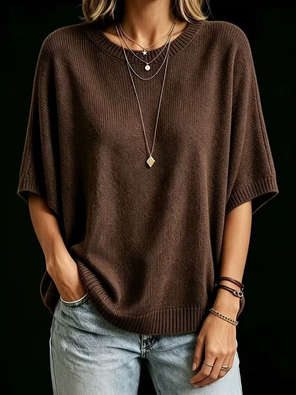 Dark brown knit top shown from the front with one hand in a pocket, worn with light jeans and bracelets. 19