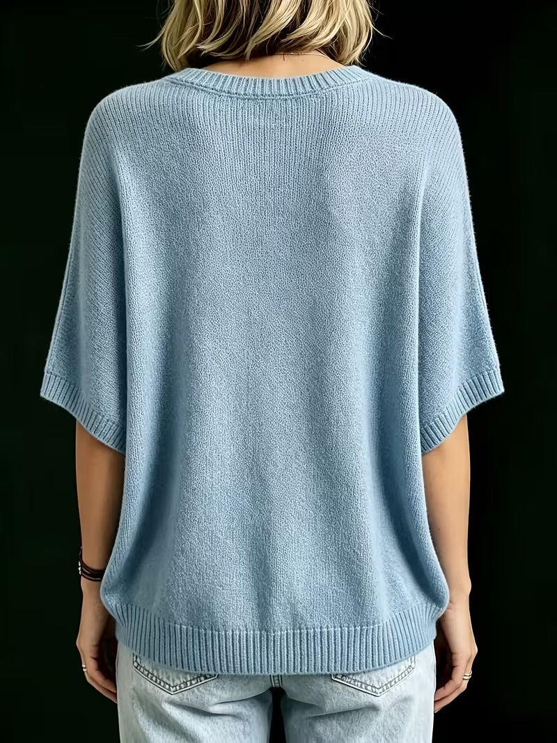 Back view of the light blue knit top on a model, showing the plain back, ribbed hem and sleeve cuffs. 14
