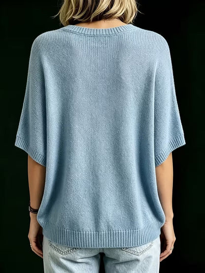 Back view of the light blue knit top on a model, showing the plain back, ribbed hem and sleeve cuffs. 14
