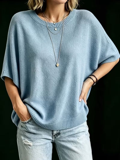 Light blue knit top worn with one hand on the hip and one in a jeans pocket, showing the relaxed fit. 15