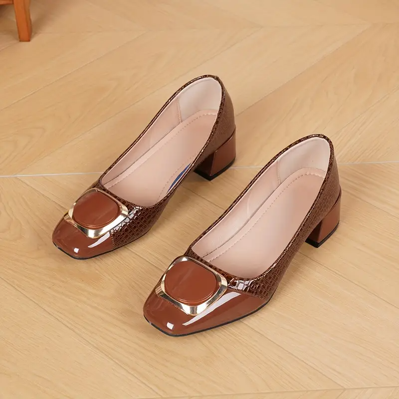 Flat lay of a pair of brown croc-effect block-heel shoes on a wooden floor, showing the soft pale lining. 4