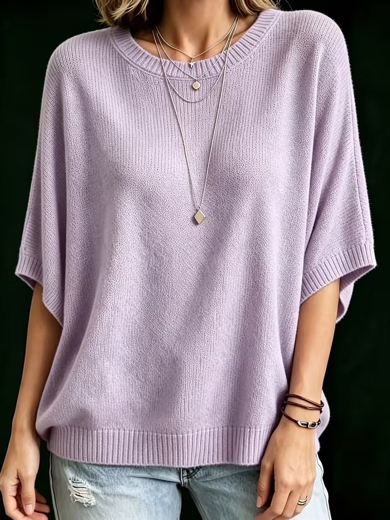Front view of the lilac knit top worn with light jeans, showing the loose body and ribbed batwing cuffs. 10
