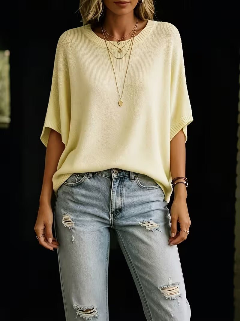 Pale yellow knit top worn with ripped light-wash jeans, shown from the front to the thigh, with relaxed fit. 5