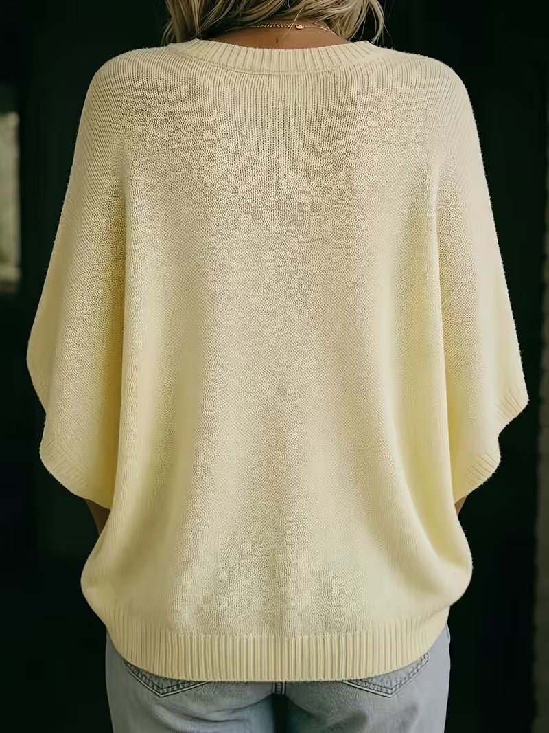 Back view of the pale yellow knit top on a model, showing the plain back and ribbed round neckline. 6