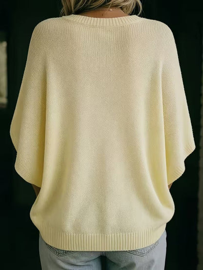 Back view of the pale yellow knit top on a model, showing the plain back and ribbed round neckline. 6