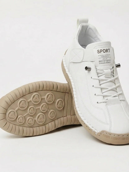 White trainers with elastic laces, one shoe tilted to show its beige studded rubber sole 4