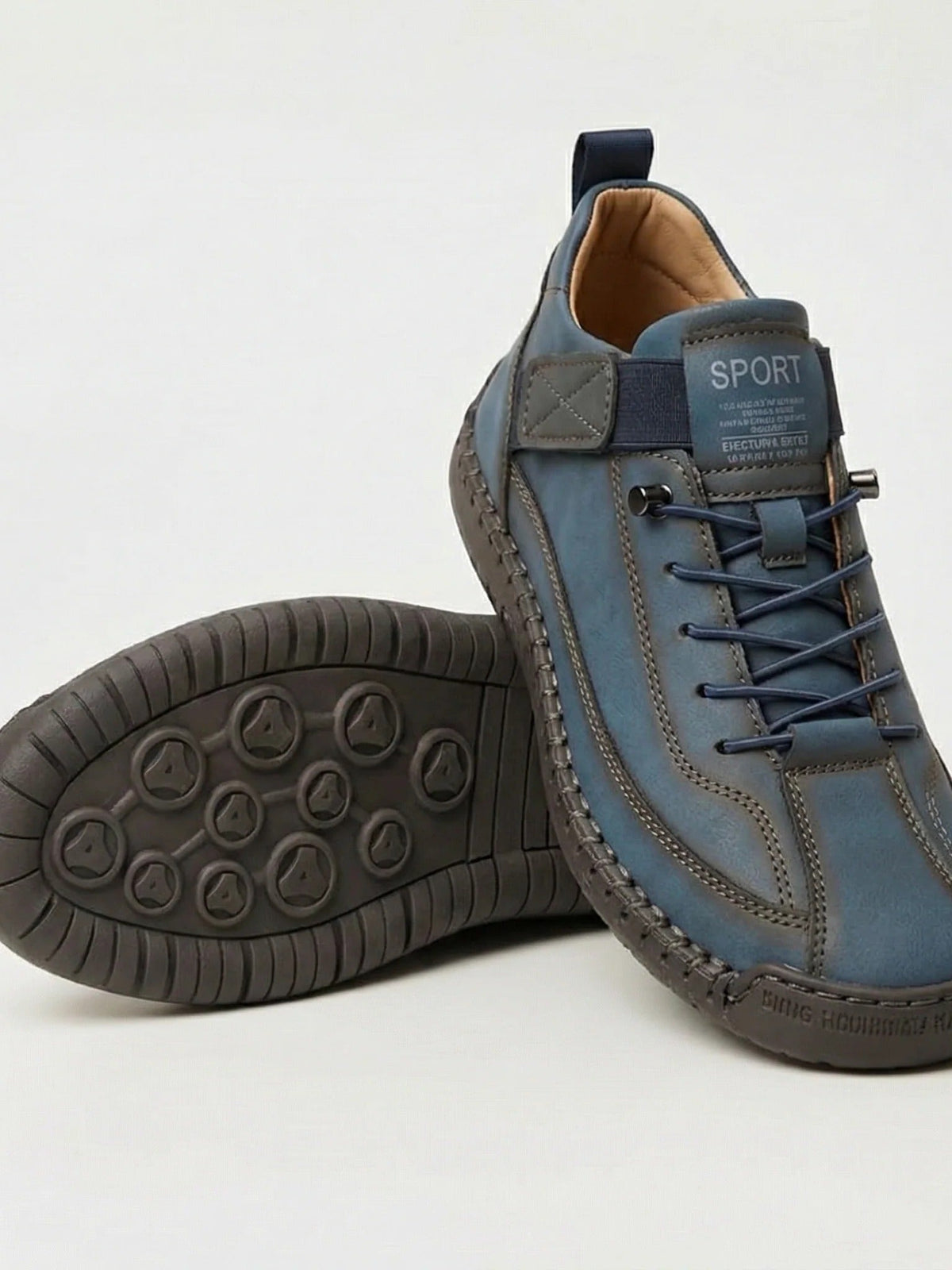 Blue slip-on trainer with elastic laces, resting on its pair to show the dark patterned sole 8