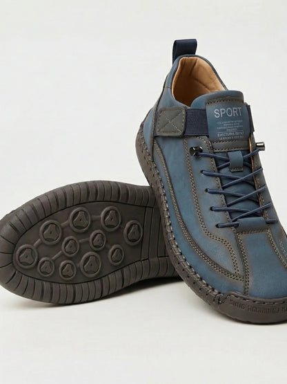 Blue slip-on trainer with elastic laces, resting on its pair to show the dark patterned sole 8