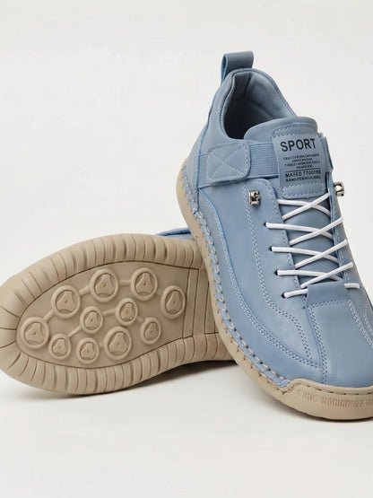 Pair of pale blue trainers with white elastic laces, one tilted to show the beige patterned sole 19