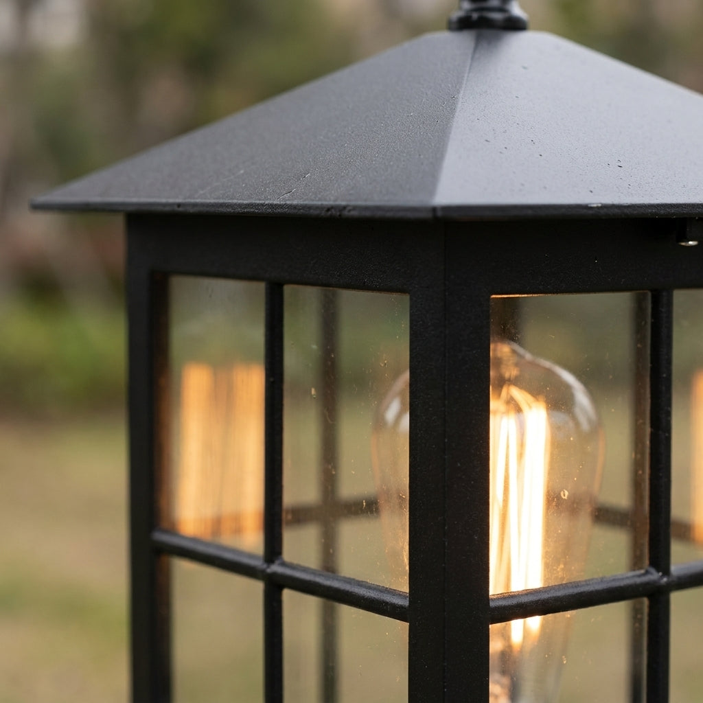 Close-up of the sloping black roof and upper glass panes, with the lit filament bulb visible inside. 6