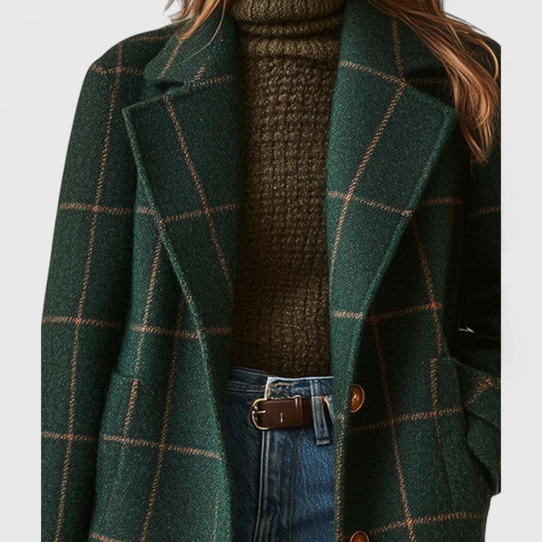 Close-up of the notched lapels and brown buttons on the green checked wool-look fabric, worn over an olive knit. 3