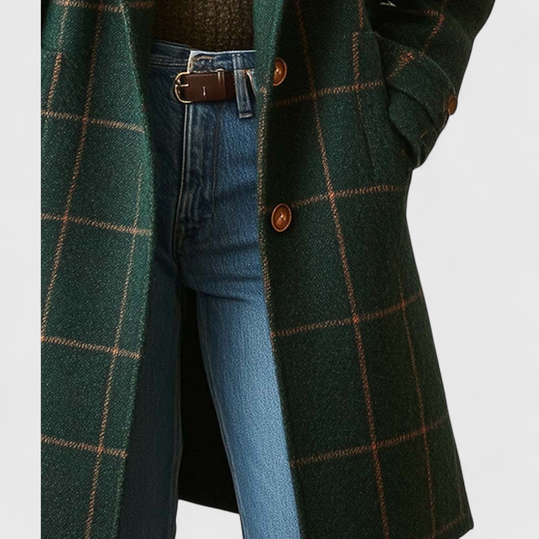 Close-up of the coat's front opening, brown buttons and a hand resting in the side pocket, worn with jeans and a belt. 5
