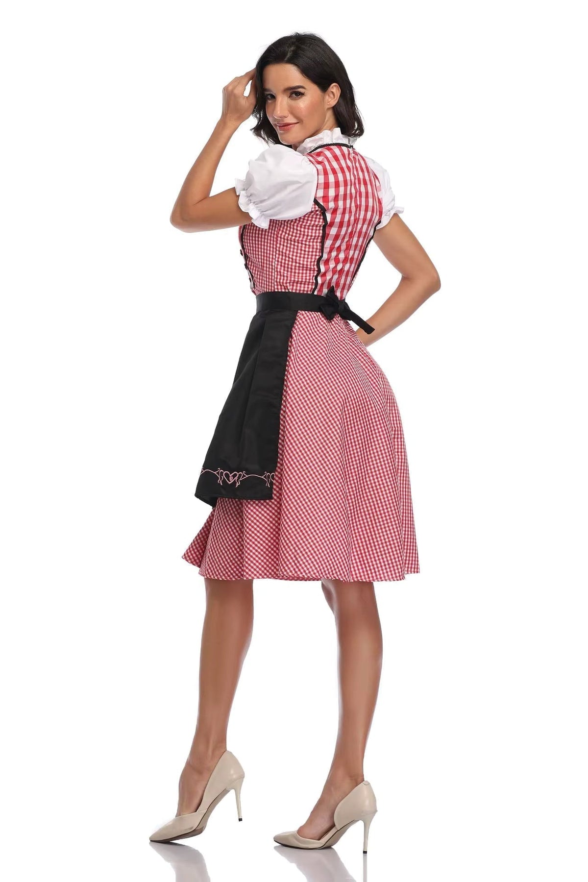 Back three-quarter view of the red gingham dirndl with white puff sleeves and a black embroidered apron tied in a bow at the waist. 2