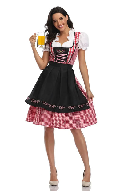 Front view of the red gingham dirndl with black bodice panel, pink lacing and black apron embroidered with pink hearts, beer mug in hand. 9