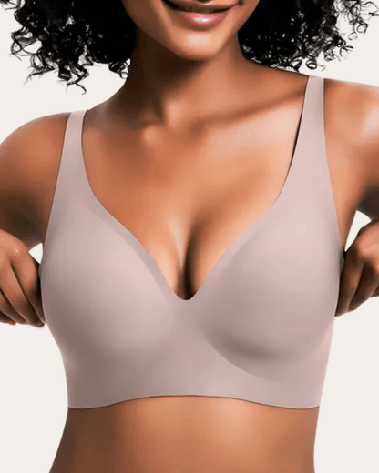 Model wearing the seamless bra in a soft taupe-pink shade, front view with smooth cups. 10