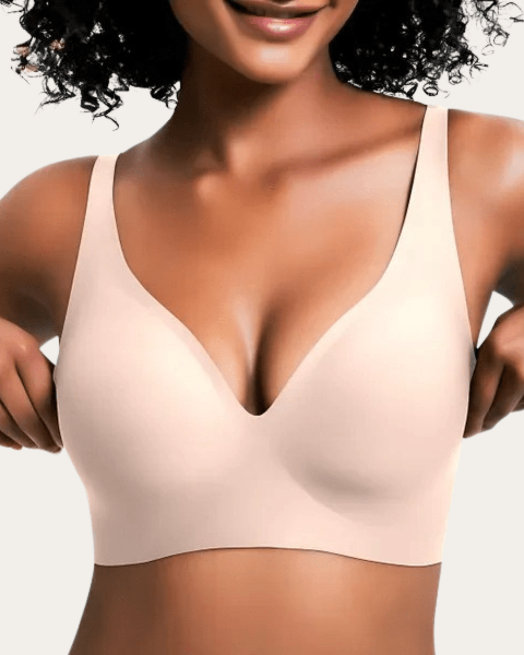 Model wearing the seamless bra in a pale blush nude shade, front view showing the deep V neckline. 6