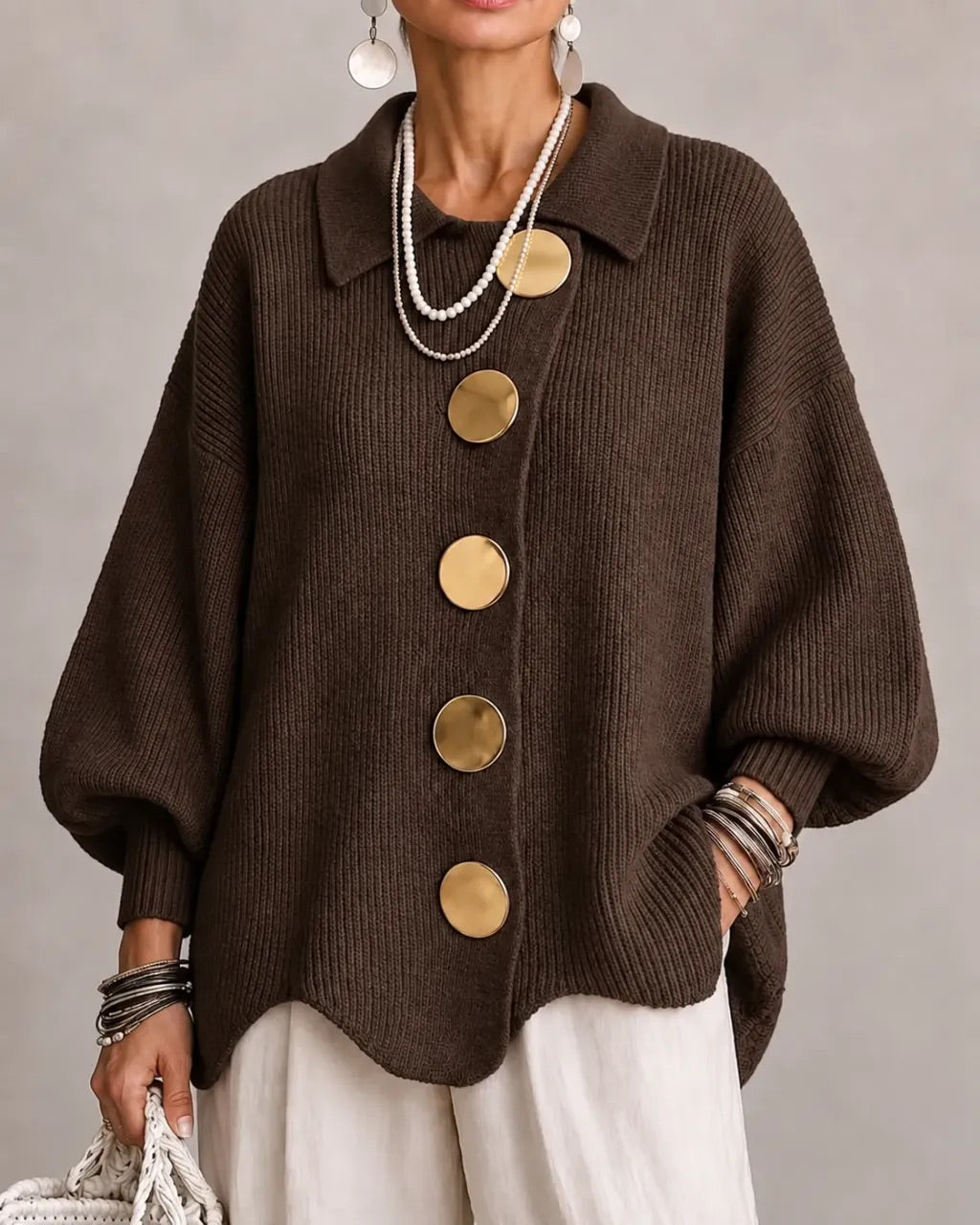 Dark chocolate-brown ribbed cardigan on a model, with oversized gold buttons and wide balloon sleeves, worn with cream trousers. 9