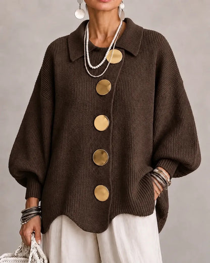 Dark chocolate-brown ribbed cardigan on a model, with oversized gold buttons and wide balloon sleeves, worn with cream trousers. 9