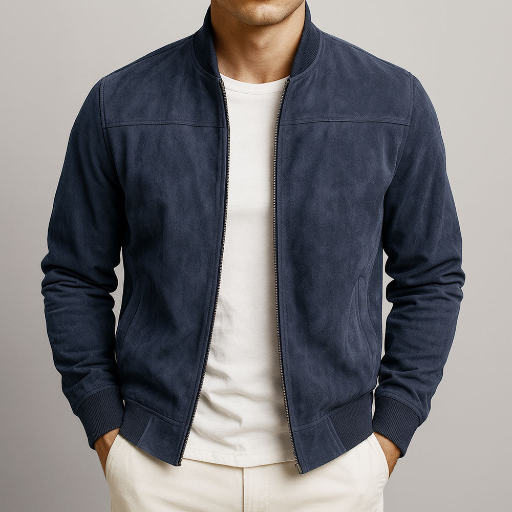 Front view of the jacket in navy blue, worn open over a cream t-shirt with both hands in the trouser pockets. 4