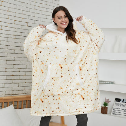 Frau in übergroßem, beigem Hoodie-Decke mit Taschen, gemütlich, warm, ideal für Zuhause.
