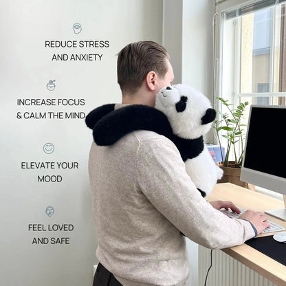 Man in a grey jumper at a standing desk with the panda plush draped over his shoulders, long arms hugging him. 2