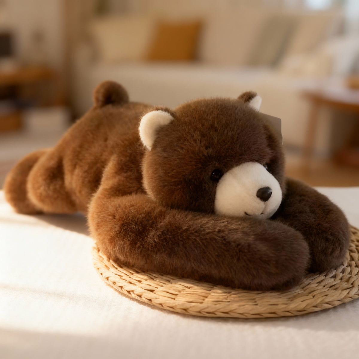 Brown teddy bear plush with a cream muzzle and ears, lying down with long arms wrapped around its head on a woven mat. 14