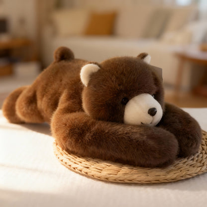 Brown teddy bear plush with a cream muzzle and ears, lying down with long arms wrapped around its head on a woven mat. 14