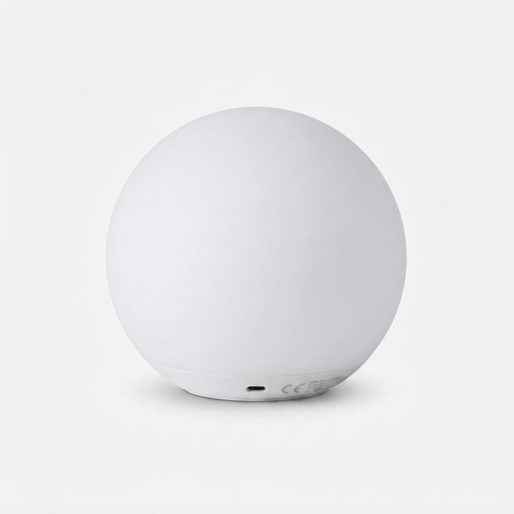 Rear view of the unlit white orb lamp on a plain background, showing the charging port on its base. 9