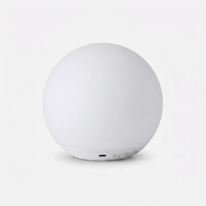 Rear view of the unlit white orb lamp on a plain background, showing the charging port on its base. 9