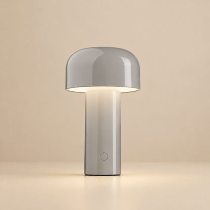 Glossy grey lamp lit against a beige backdrop, with a round button on the stem 32