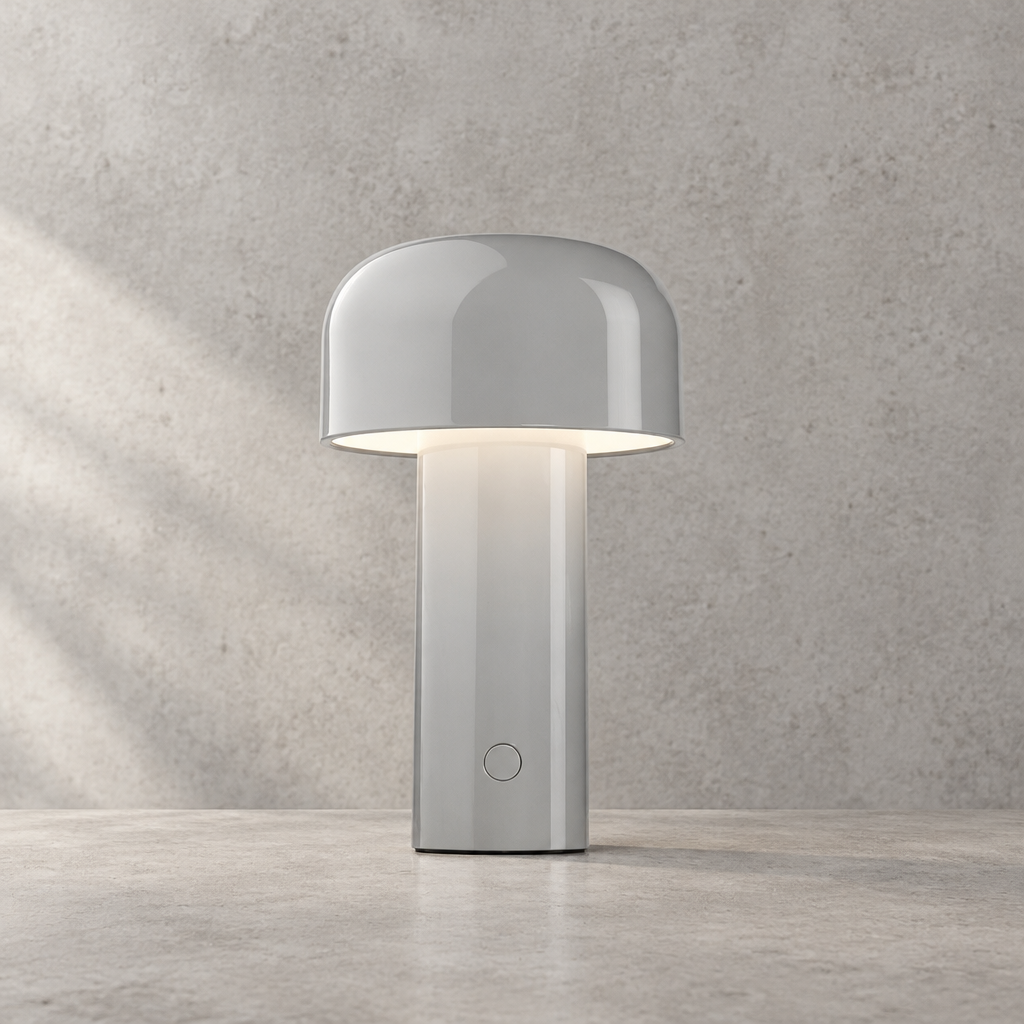 Glossy light grey lamp lit against a textured wall, round touch button visible on the stem 32