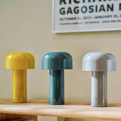 Yellow, blue and grey mushroom lamps in a row on a wooden shelf below a framed poster 11