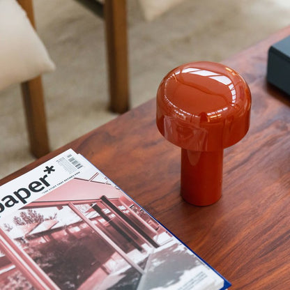 Red mushroom lamp on a wooden coffee table beside a magazine, seen from above 14
