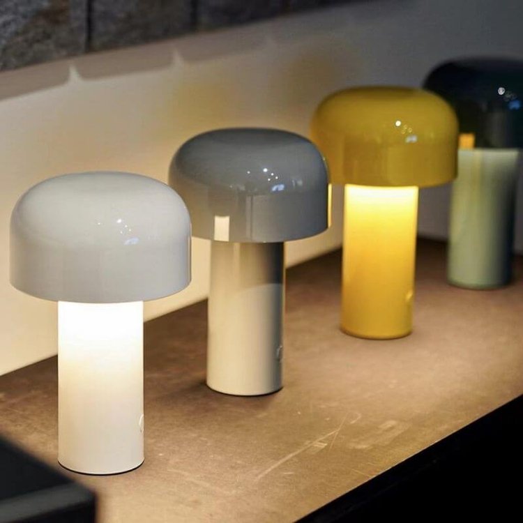 Row of lit lamps in white, grey and yellow with a darker one behind, on a shelf 18