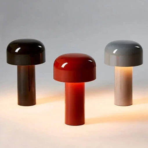 Three mushroom lamps side by side in dark brown, red and grey, each softly lit 25