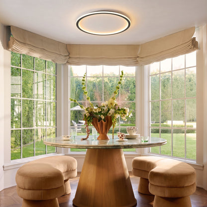 Ring light glowing above a round dining table in a bay-windowed nook, with flowers in a vase and curved stools. 7