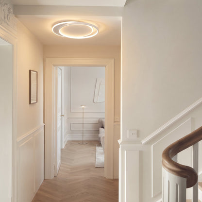 Ring light lit in a panelled hallway with a doorway and curved staircase banister 7