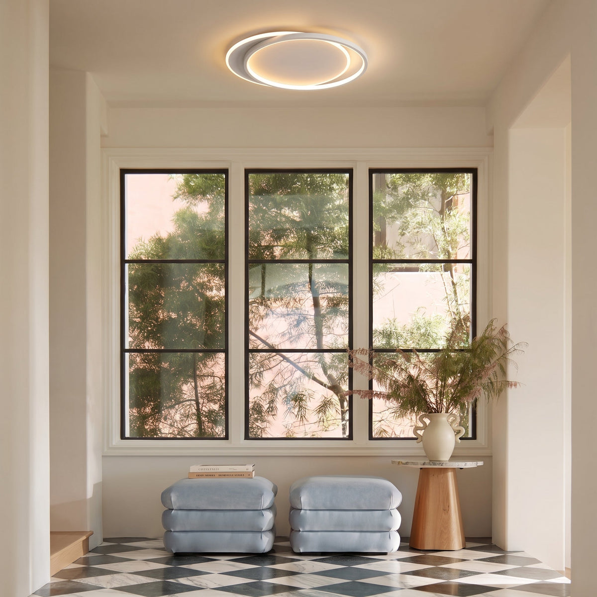 Ring light above a bright entrance with large windows, blue ottomans and a chequered floor 9
